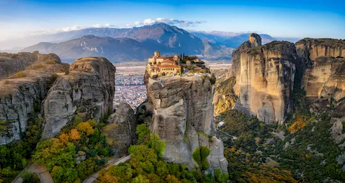 Greece, Meteora - Sunrise view of the Meteora mountains with Agia Triada Monastery situated on a cliff high above the valley