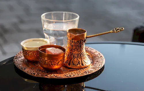 Bosnia and Herzegovina, Sarajevo - Traditional Bosnian coffee served in an ornate copper cezve with Turkish delight and a glass of water