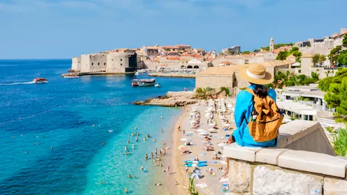 Croatia, Dubrovnik - Traveler admiring the historic walls of Dubrovnik and the Adriatic Sea from a scenic viewpoint