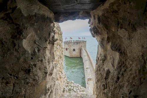 Serbia - Golubac Fortress tower on the Danube River seen through a stone wall aperture
