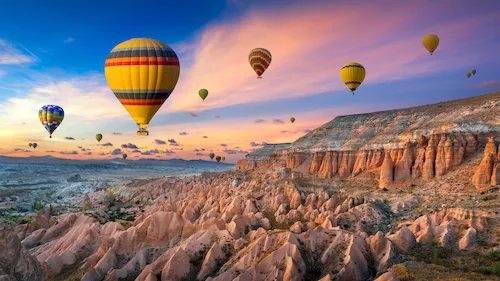 Turkey, Cappadocia - Hot air balloons and Red Valley at sunset in Goreme