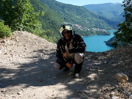 Motorcyclist overlooking Lake Piva and the surrounding mountain landscape in Montenegro