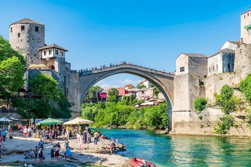 Bosnia and Herzegovina, Mostar - People walking across the iconic Stari Most (Old Bridge) over the Neretva River