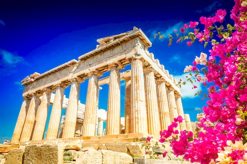 Greece, Athens - Parthenon temple on the Acropolis hill against a bright blue sky with flowers