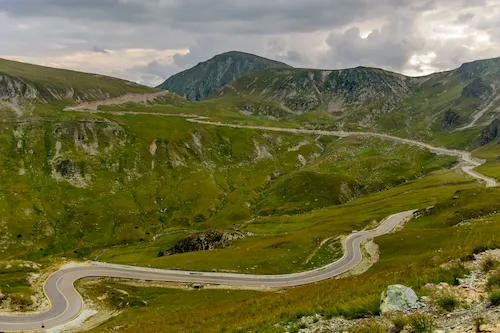 Romania - Transalpina Road surrounded by greenery and mountains on a cloudy day